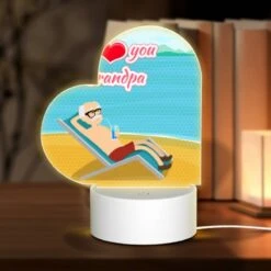 Love Acrylic Night Light, A Man Is Sitting On A Beach Chair With A Drink In His Hand.