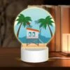 Round Acrylic Night Light, A Small White House With A Red Roof Is Situated On A Sandy Beach. -Nuas Diy Shop 5c44865e0bad8175d4fe149a685d09694dc59abc