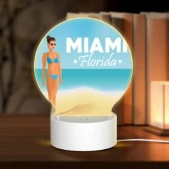 Round Acrylic Night Light, A Woman In A Bikini Stands On A Beach In Front Of A Sign That Reads "Miami Florida."